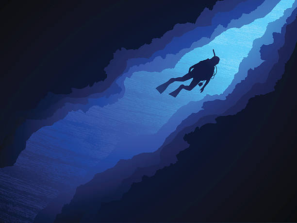 A lone scuba diver explores a coral canyon.
